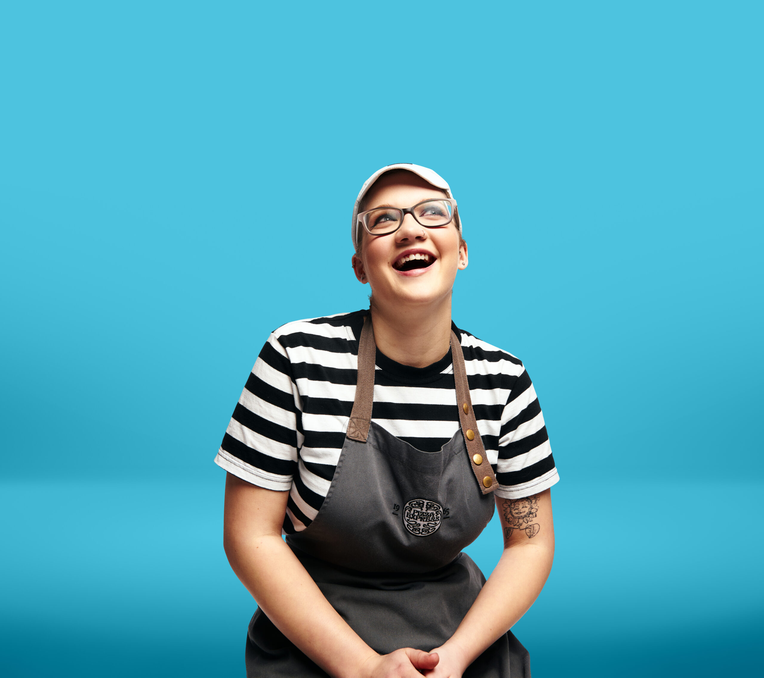 Aiste Kinderyte from PizzaExpress smiling in front of a light blue background